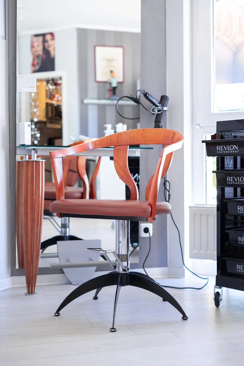 Friseurplatz mit Spiegel und Pflegeprodukten im Salon P